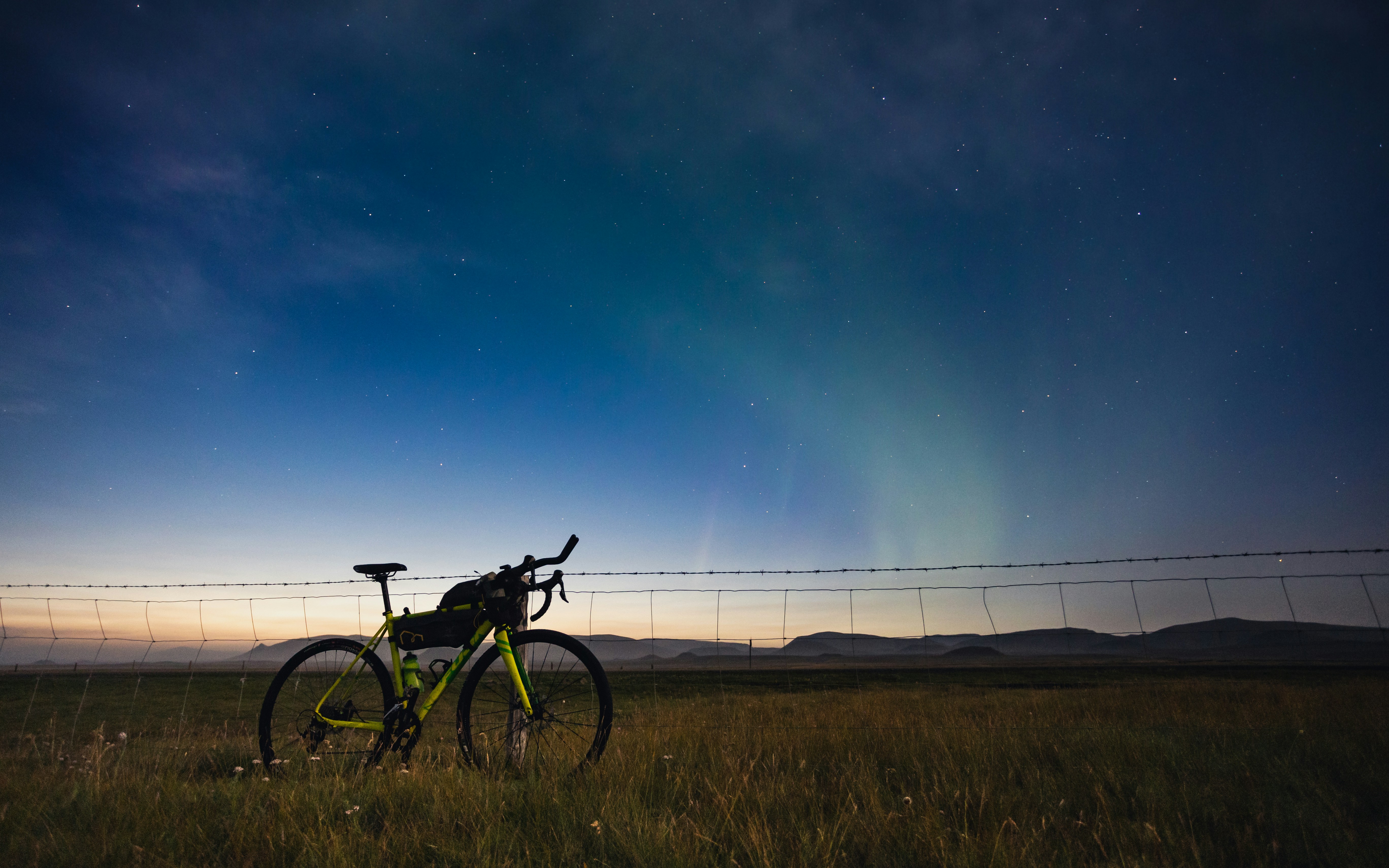 a bike is parked in a field with a fence