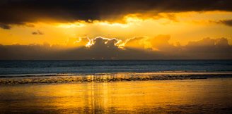 A vibrant sunset over the beaches of Lombok, with golden light reflecting on the waves.