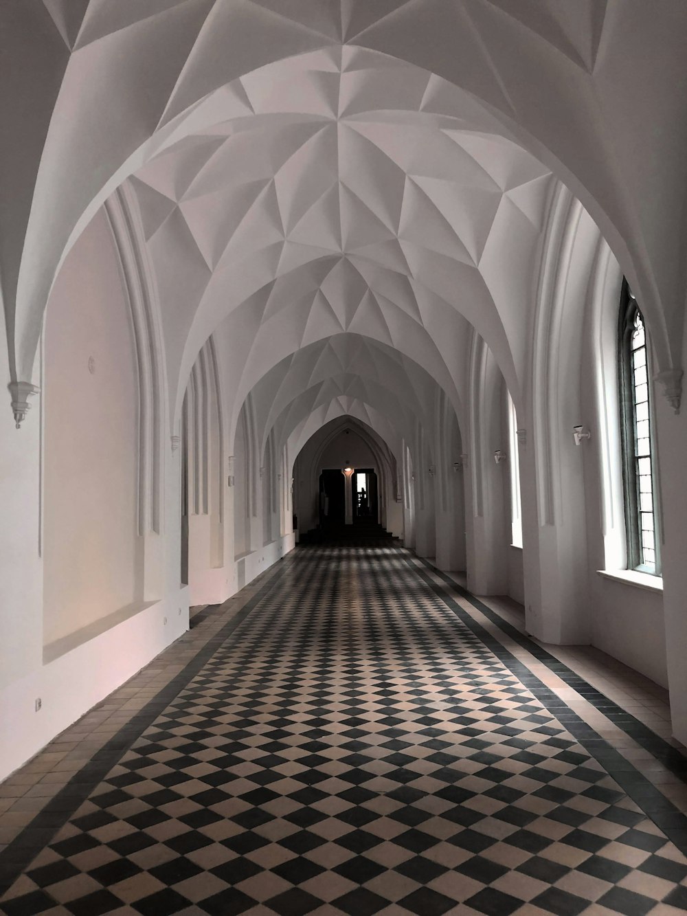 a long hallway with black and white checkered flooring