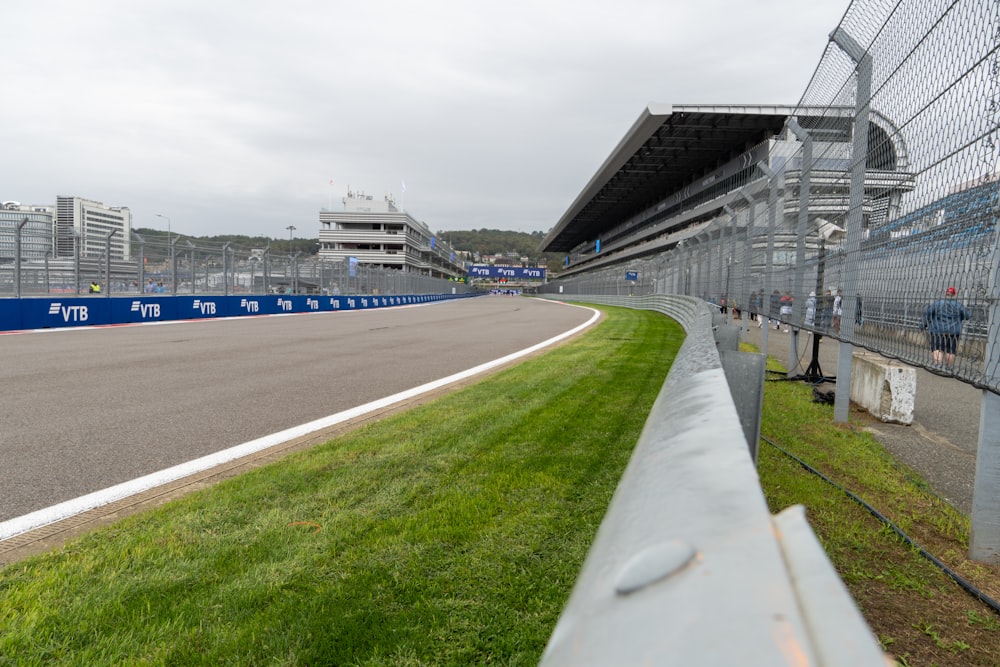 a race track with grass and a building in the background