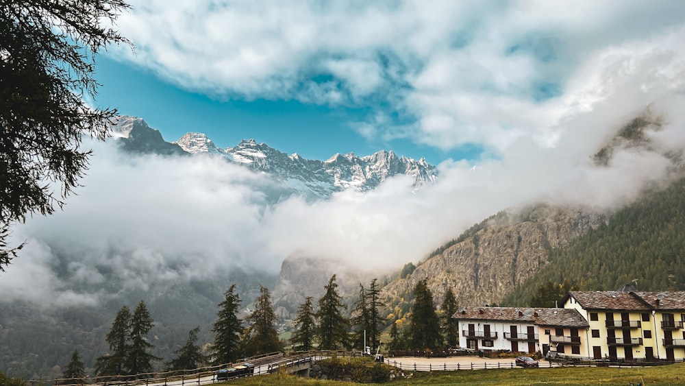 a house in the middle of a field with mountains in the background