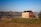 a house sitting on top of a hill next to a lake