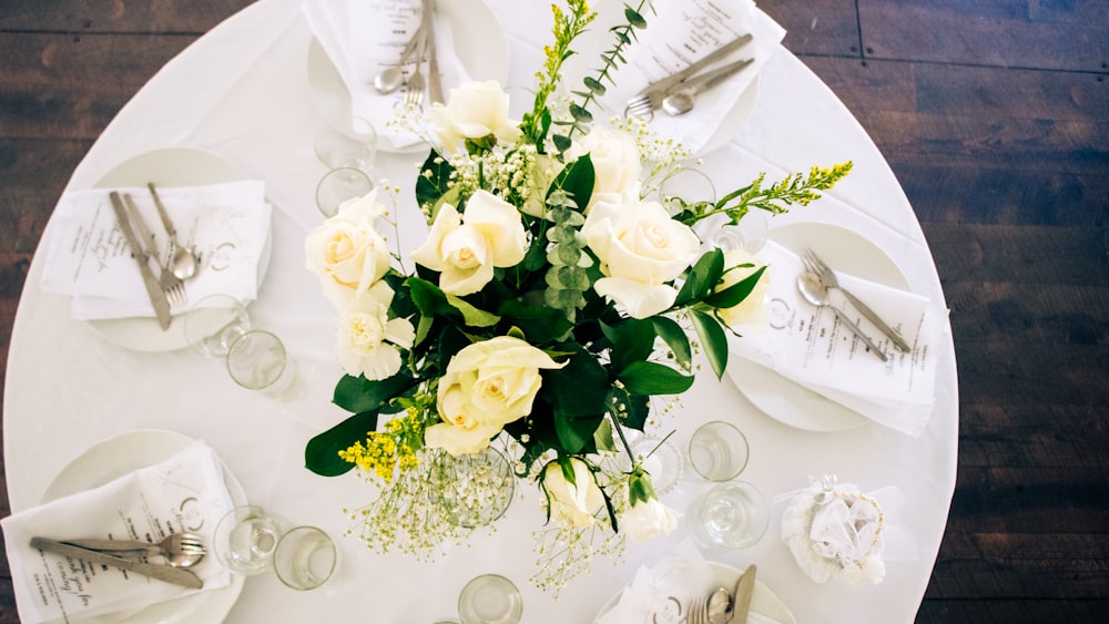 uma mesa branca com um ramo de flores sobre ela