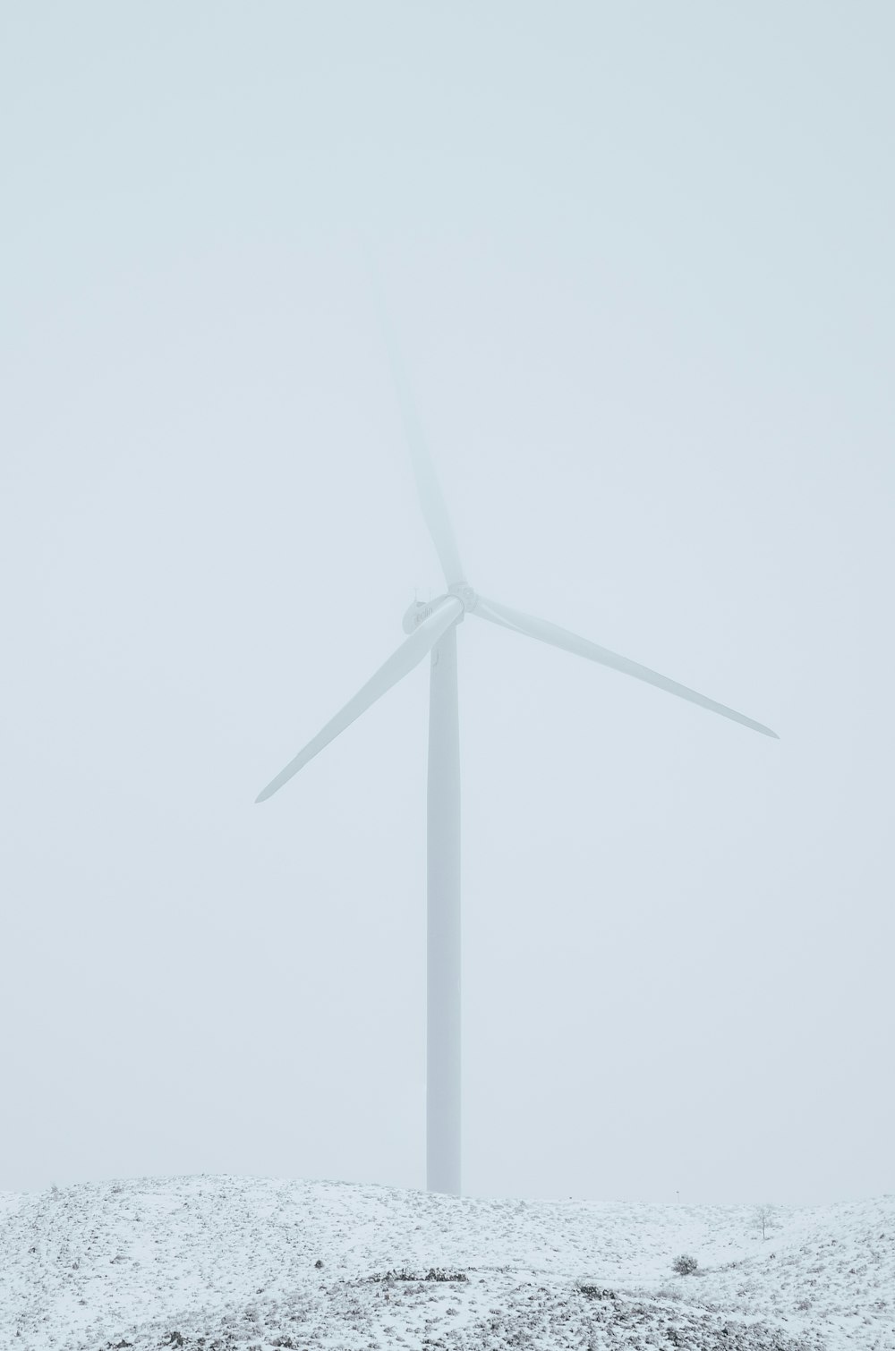 a wind turbine on a snow covered hill