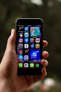 a person holding a smart phone in their hand