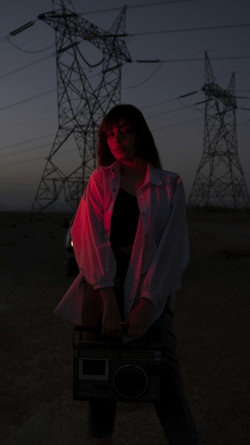 a woman holding a radio in front of a power line