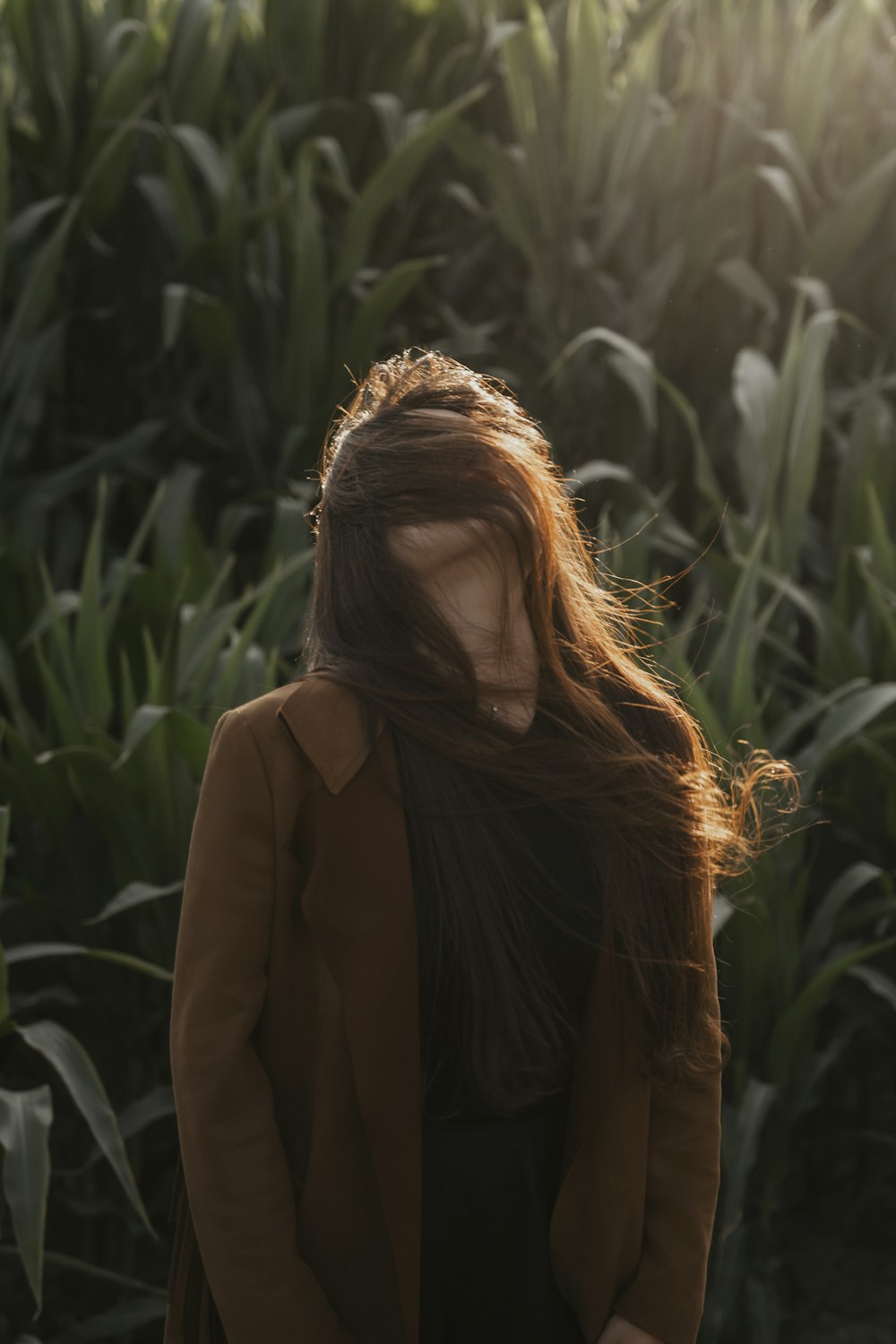 a woman standing in front of a corn field