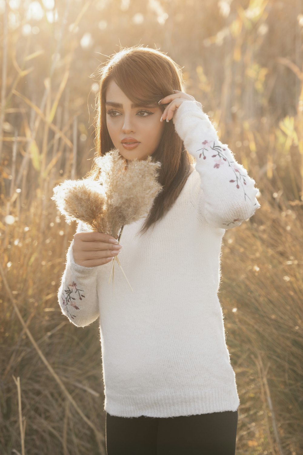 uma mulher em um suéter branco segurando um urso de pelúcia