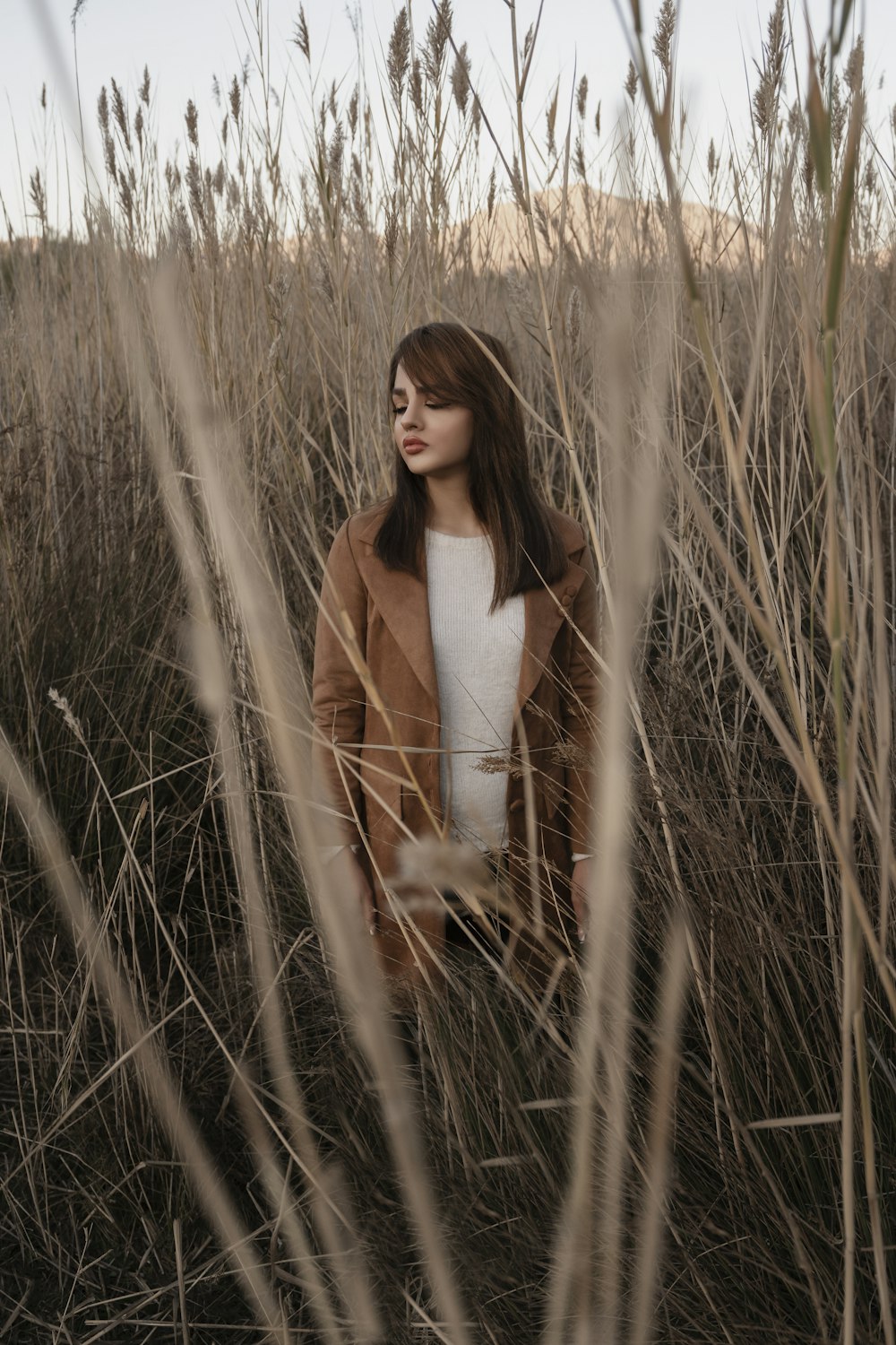 a woman standing in a field of tall grass