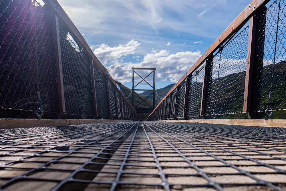 a metal grate on a bridge with mountains in the background