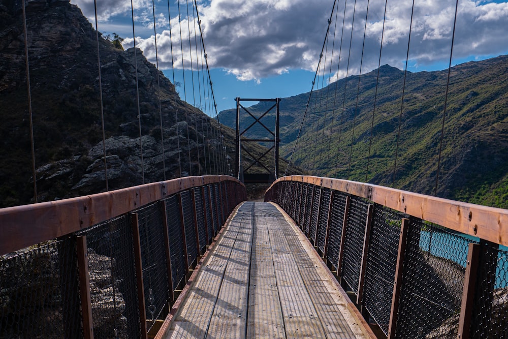 a wooden bridge with mountains in the background