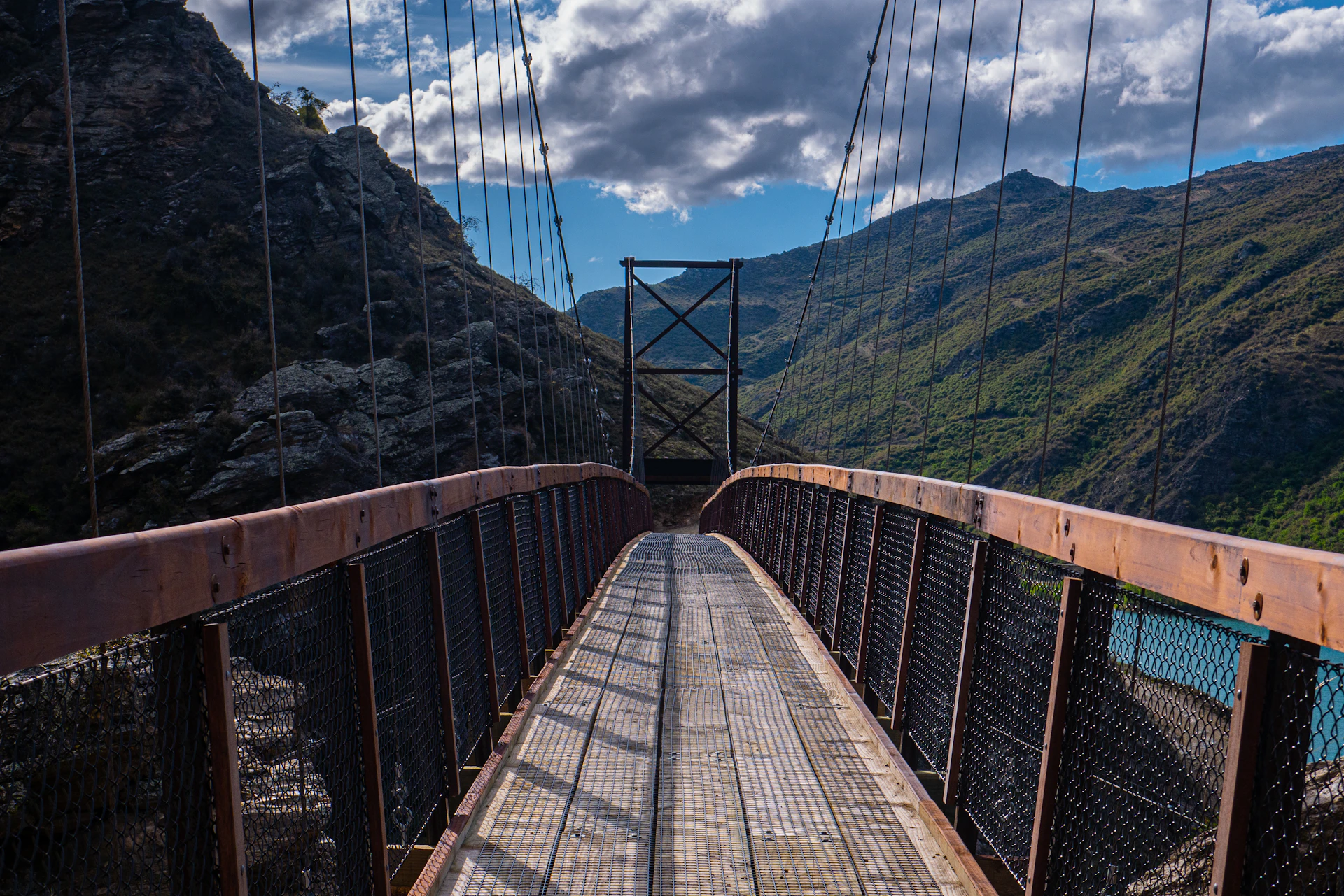 a wooden bridge with mountains in the background