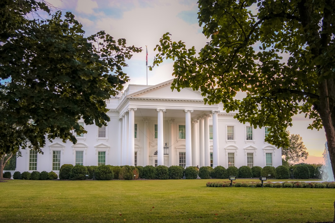 a large white building with a flag on top of it, Sunset at the White House