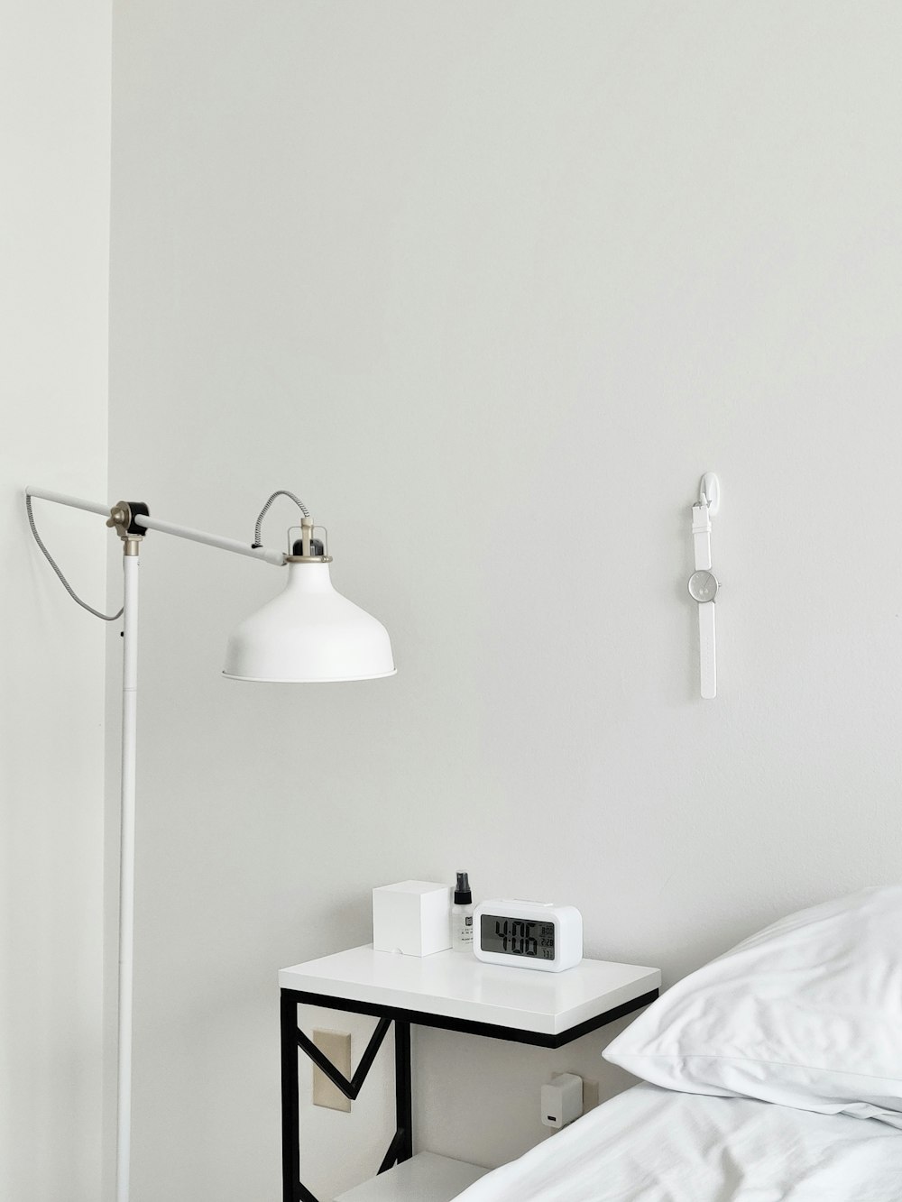 a bed with a white comforter and a white lamp