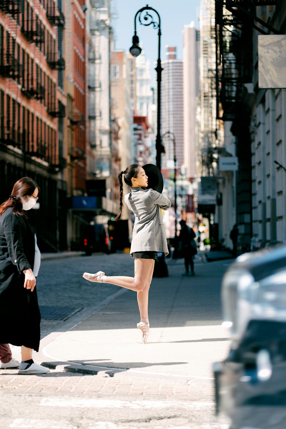 a woman standing on a sidewalk next to another woman