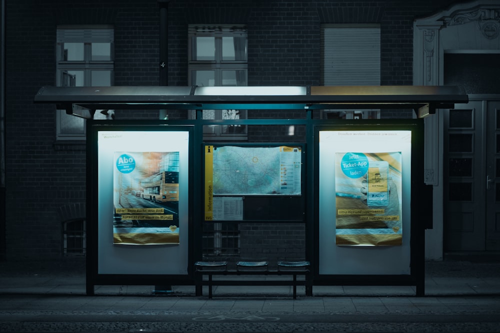a bus stop at night with a bus stop sign