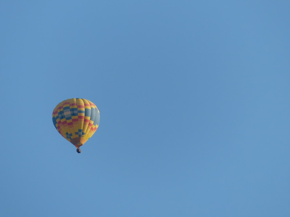 a hot air balloon flying through a blue sky
