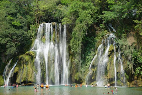 a group of people standing in front of a waterfall