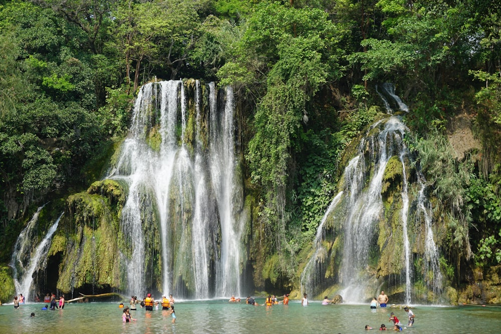 Un gruppo di persone in piedi di fronte a una cascata