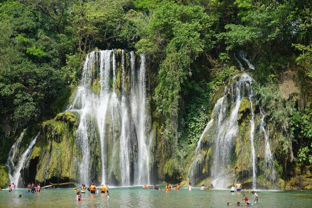 a group of people standing in front of a waterfall