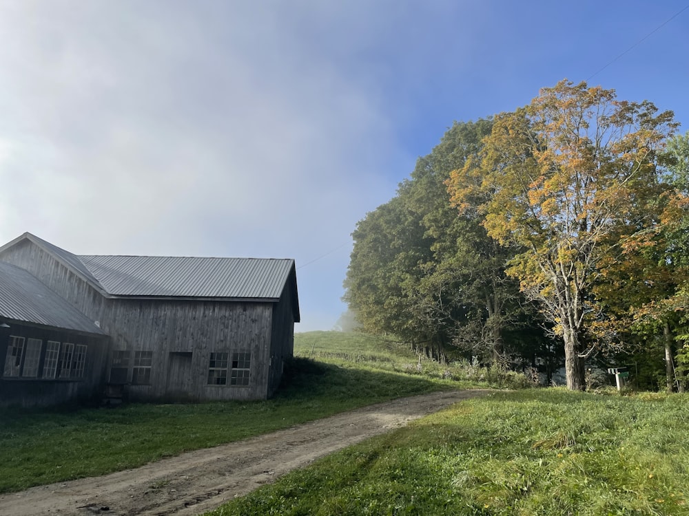 a barn and a dirt road in a field