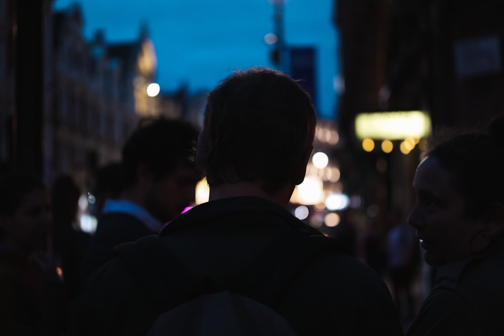 a group of people walking down a street at night