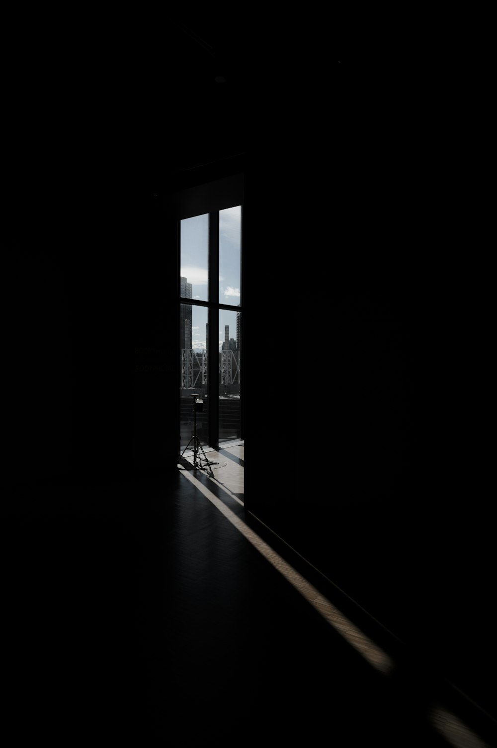 an open door in a dark room with a view of a city