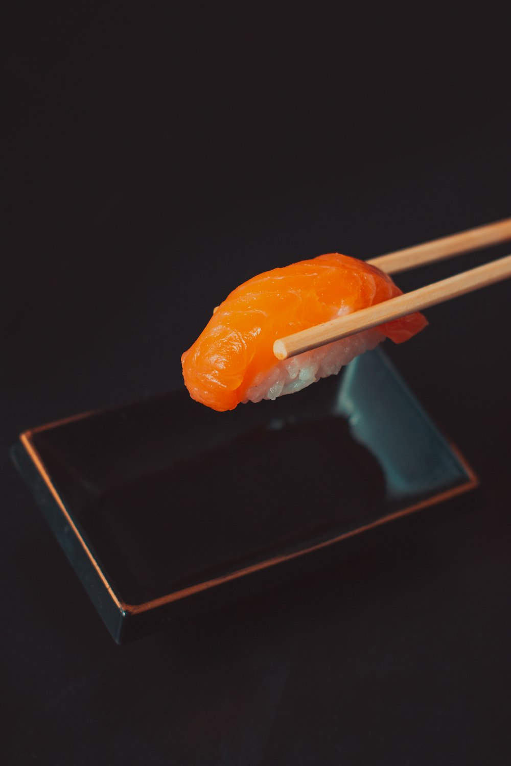 un morceau de sushi avec des baguettes qui en sortent