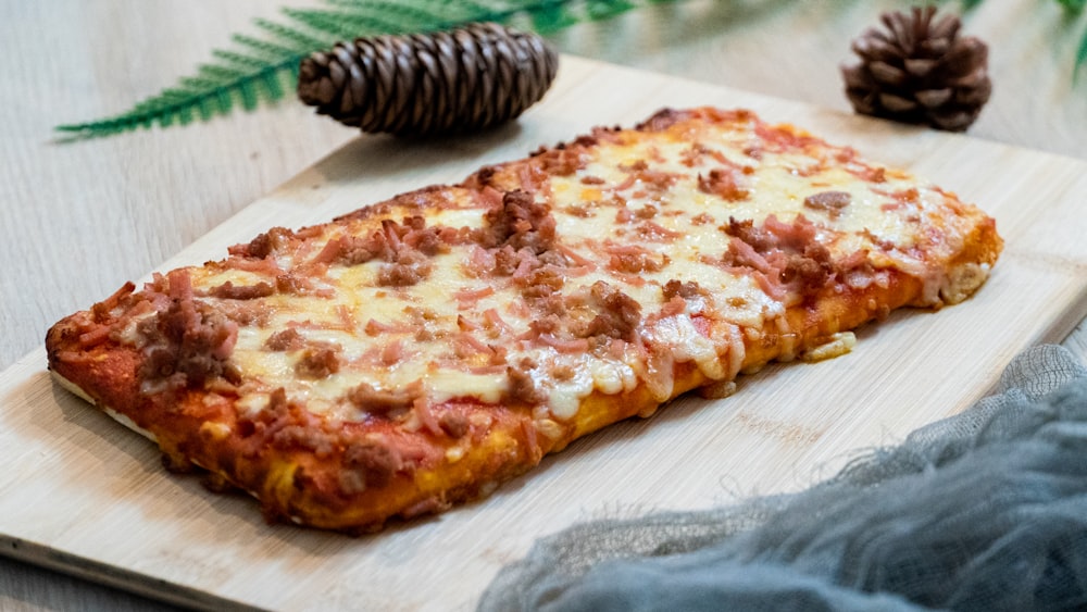 a pizza sitting on top of a wooden cutting board