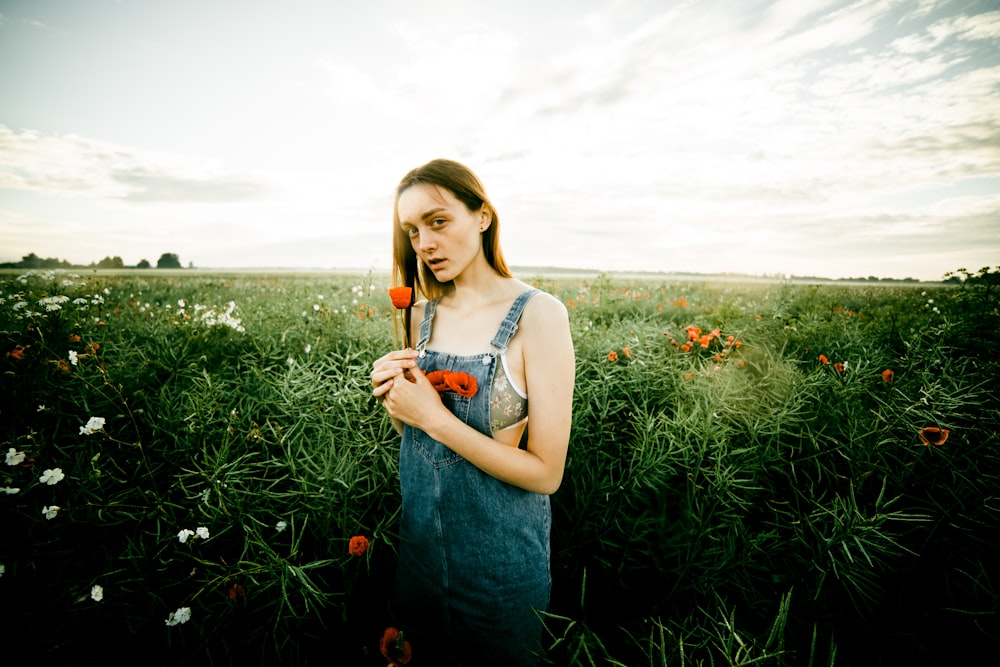 a woman standing in a field of flowers