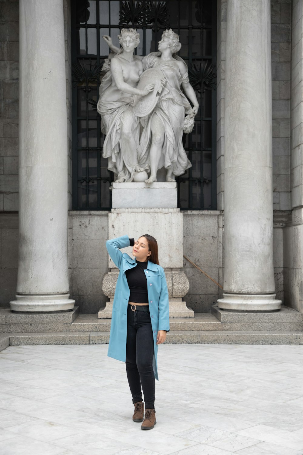 a woman standing in front of a statue