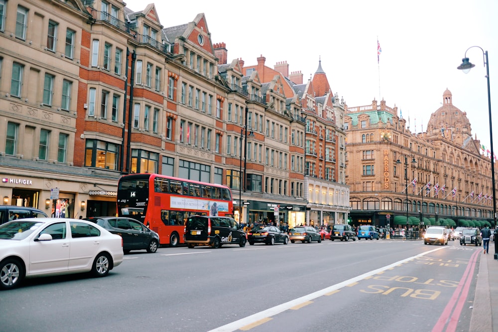 a double decker bus driving down a street next to tall buildings