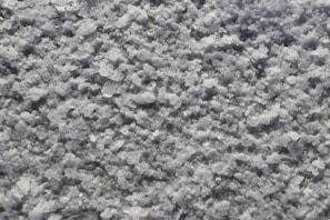A close-up of high-purity silica grains on a textured surface.