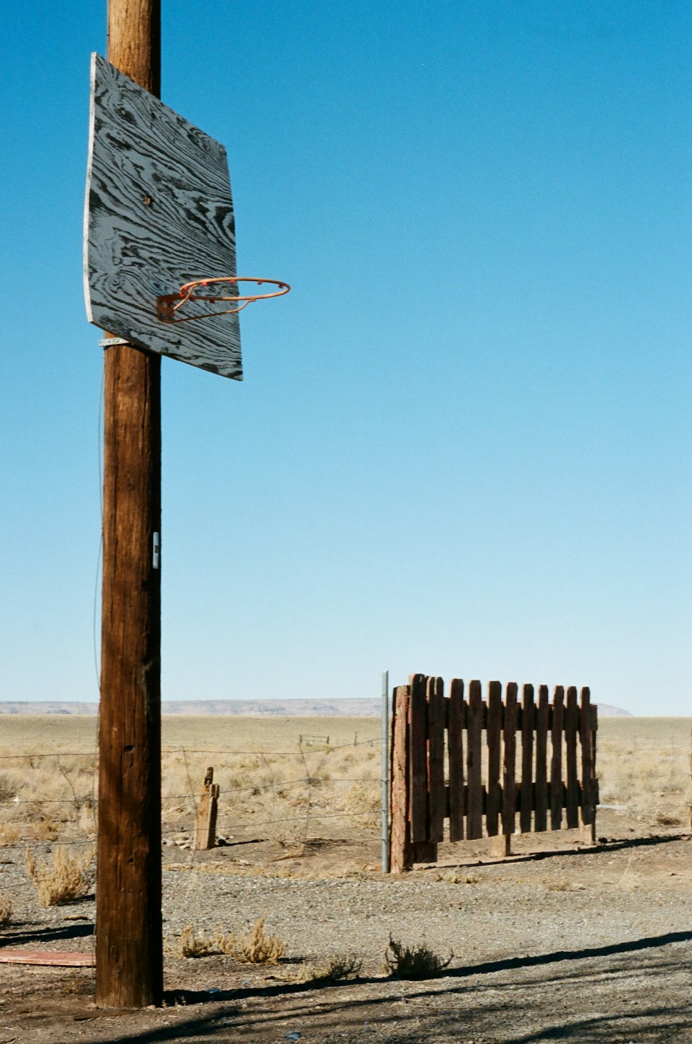 a wooden pole with a basketball hoop attached to it