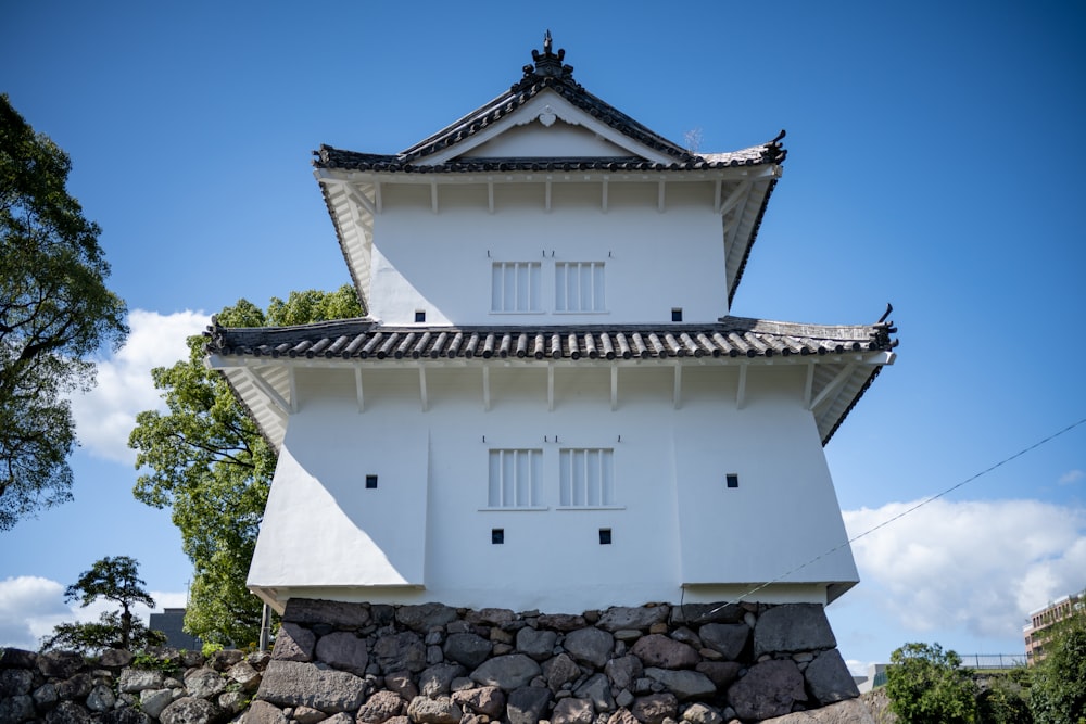 a tall white building sitting on top of a stone wall