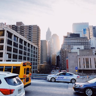 A sleek NYC Sprinters bus parked in front of a bustling New York City skyline at sunset.