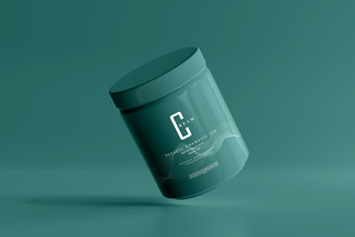 A green cosmetic jar with a minimalist design, featuring the letter 'C' prominently on its front. The jar appears to be floating against a solid green background, creating a sense of simplicity and elegance.