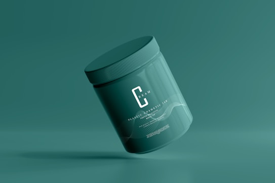 A green cosmetic jar with a minimalist design, featuring the letter 'C' prominently on its front. The jar appears to be floating against a solid green background, creating a sense of simplicity and elegance.