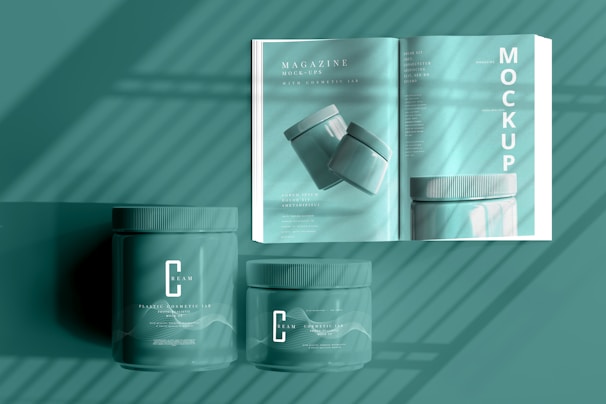 An open magazine showcases cosmetic jars with a minimalistic design. The scene includes two jars placed in front of the slightly open magazine, under a series of soft shadows that give a calm atmosphere. The entire setup features a sleek and modern aesthetic with consistent color tones.