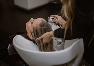 a woman getting her hair cut by a hair stylist