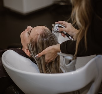 a woman getting her hair cut by a hair stylist