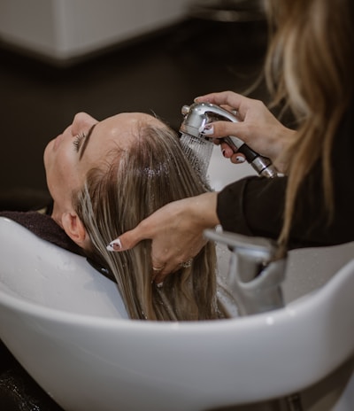 a woman getting her hair cut by a hair stylist