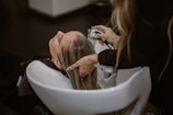 A stylist performing a relaxing scalp massage on a client