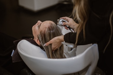 a woman getting her hair cut by a hair stylist