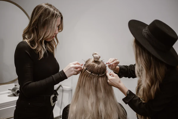 Hair specialist fitting a wig for a client
