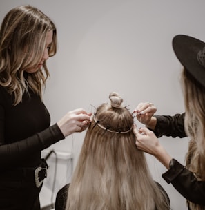 a woman getting her hair styled by another woman