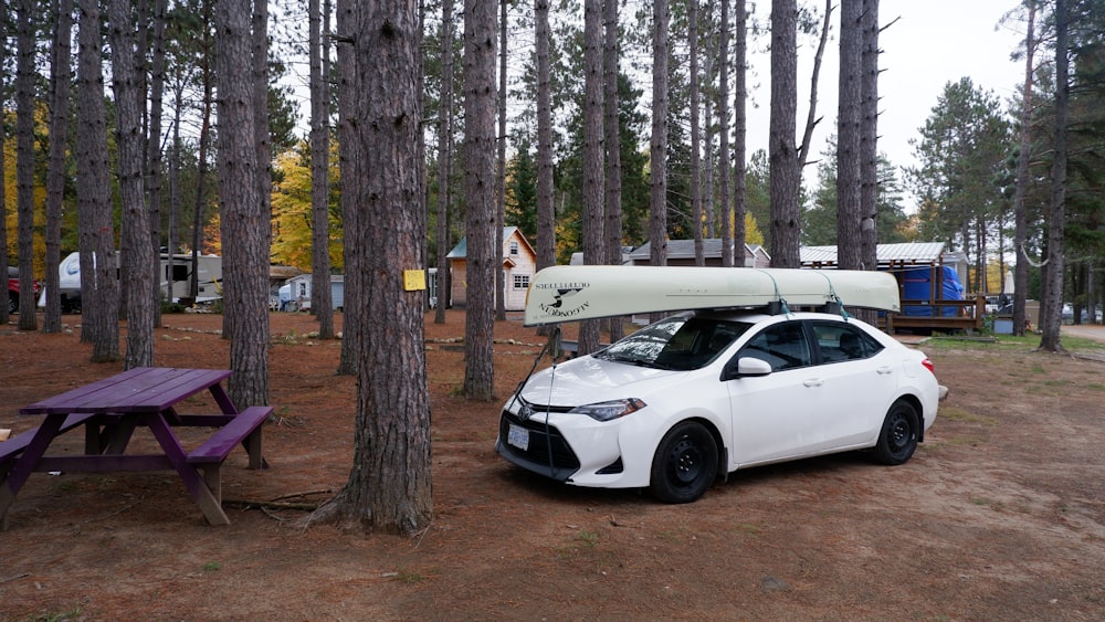 a white car with a kayak on top of it