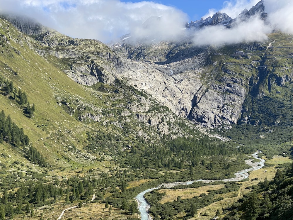 a river running through a valley surrounded by mountains