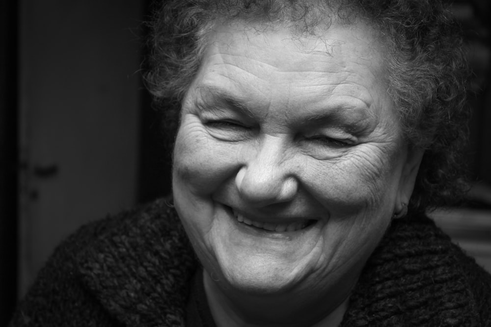 a black and white photo of a woman smiling