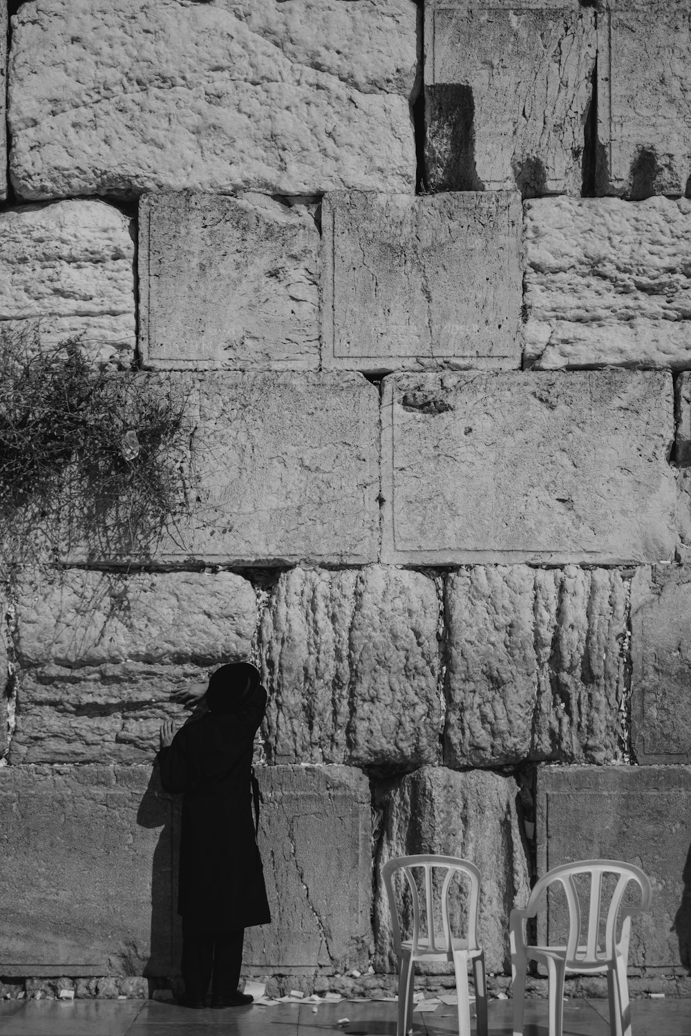 a person standing in front of a stone wall